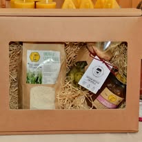 Confezione regalo con miele, conserve, farina e candele di cera d'api