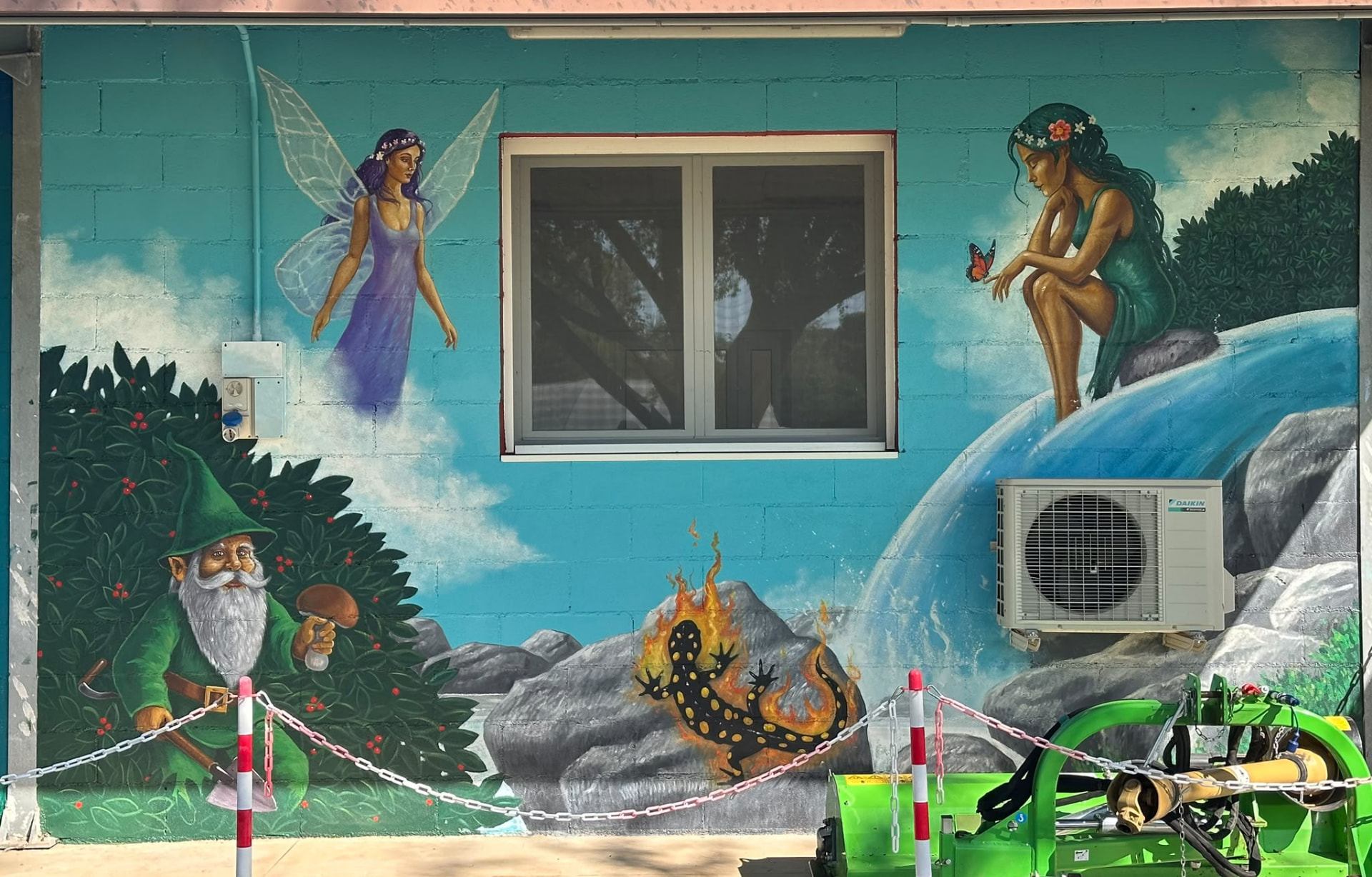 Murales dipinto a mano sulla parete della fattoria con fata, gnomo e salamandra